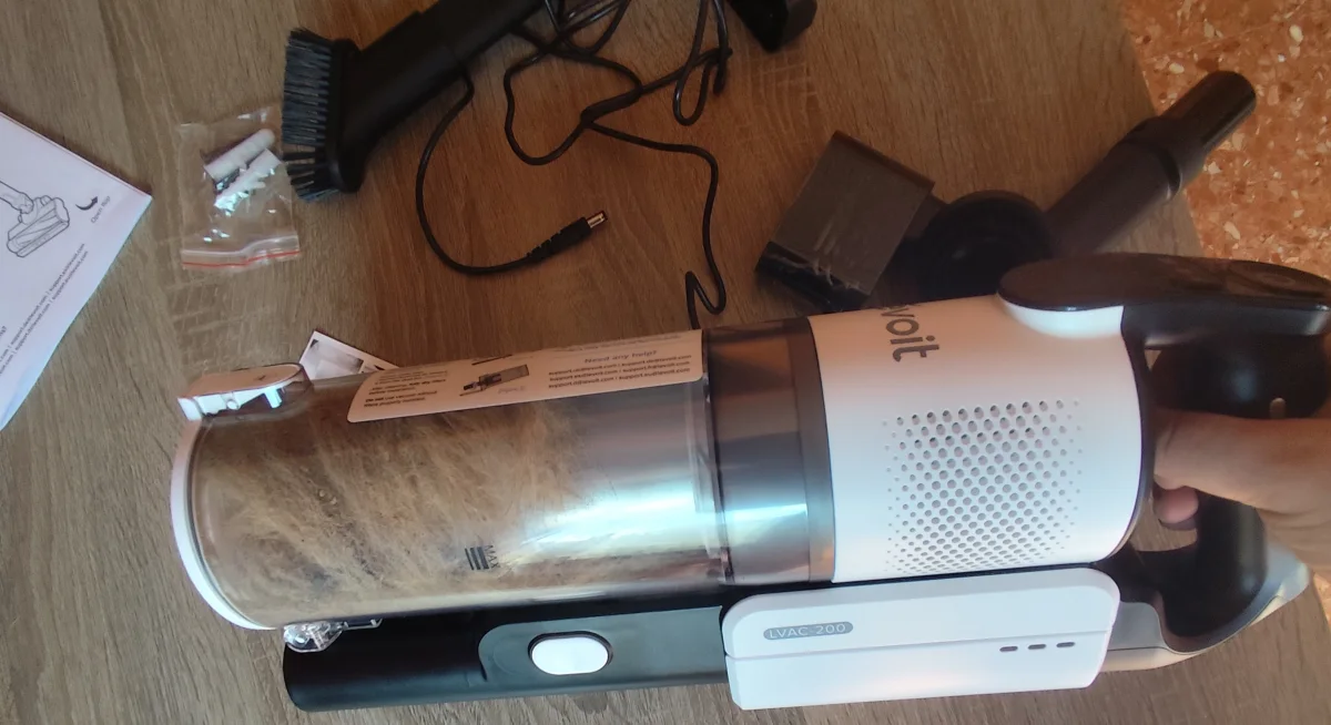 Levoit LVAC-200 after use with debris visible in the dust bin and the removable battery attached